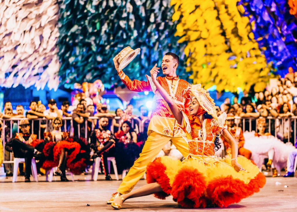 Brazilian folk dancers dances quadrilha in vivid costumes during a traditional June festival celebration.